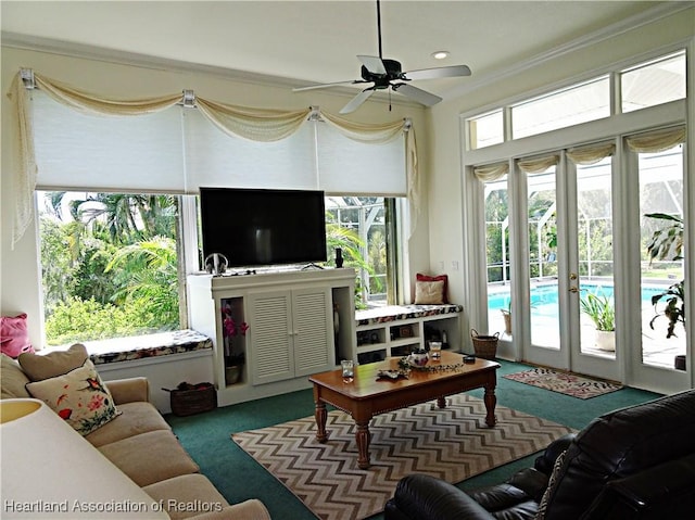 living room featuring carpet floors, ornamental molding, and ceiling fan