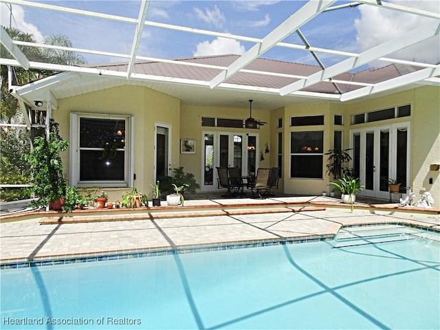 back of property featuring french doors, stucco siding, an outdoor pool, and a patio area