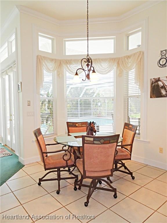 tiled dining space featuring an inviting chandelier and ornamental molding