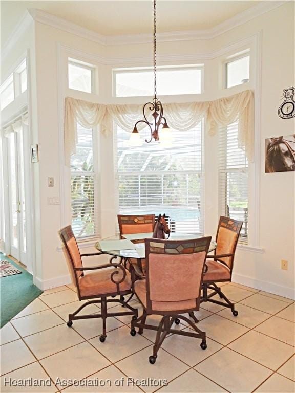dining space with light tile patterned flooring, ornamental molding, a chandelier, and baseboards