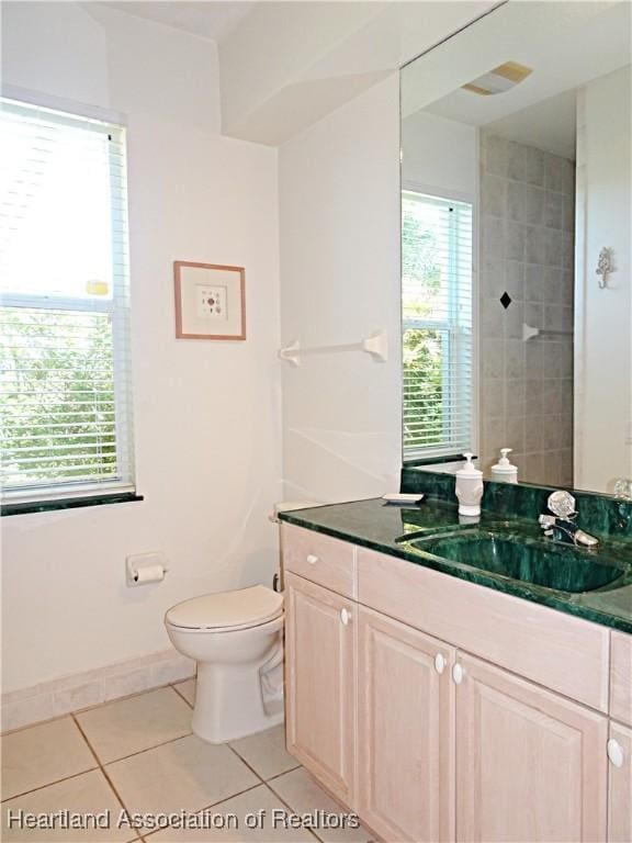 bathroom featuring tile patterned flooring, toilet, vanity, and baseboards