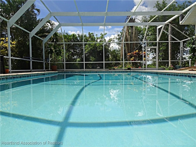 view of pool with glass enclosure