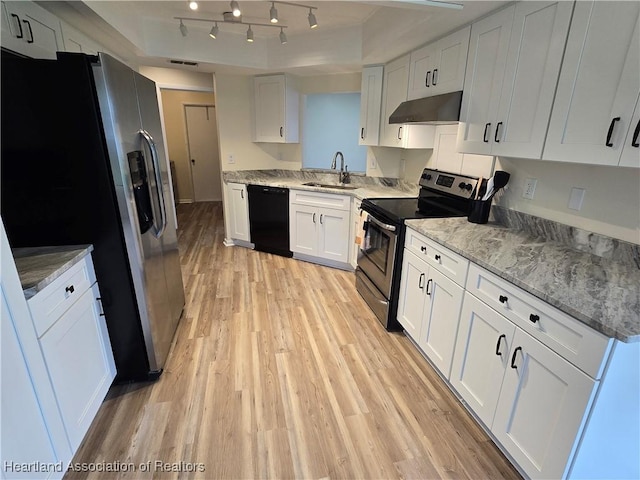 2713 Par Rd, Sebring, FL 33872 - kitchen with appliances with stainless steel finishes, exhaust hood, a raised ceiling, light wood-type flooring, and white cabinets