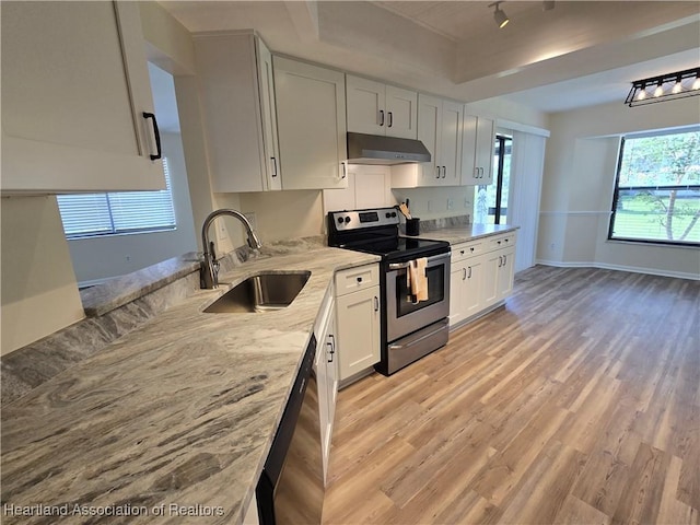 2713 Par Rd, Sebring, FL 33872 - kitchen with appliances with stainless steel finishes, under cabinet range hood, light stone countertops, light wood-style flooring, and white cabinets