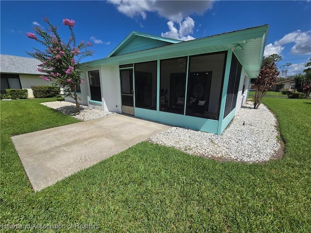 2713 Par Rd, Sebring, FL 33872 - rear view of house with a sunroom, a yard, and stucco siding