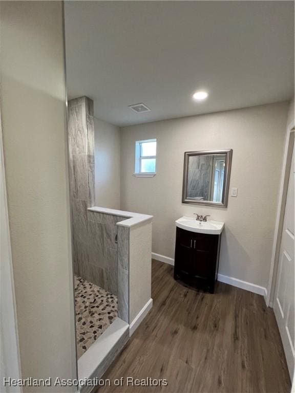 bathroom featuring vanity, hardwood / wood-style floors, and a shower