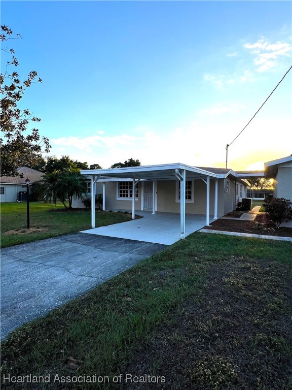 view of front of house with a carport and a yard