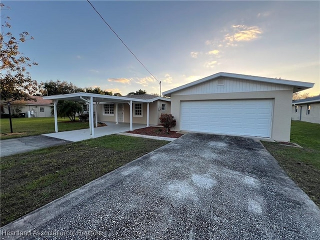 view of front of house with a garage, a yard, and a carport