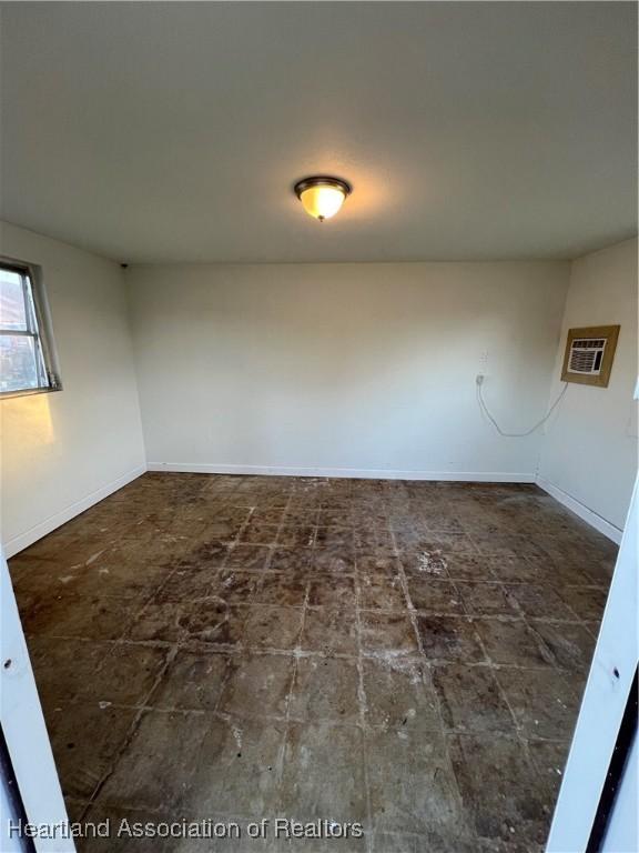 unfurnished room featuring a wall mounted AC
