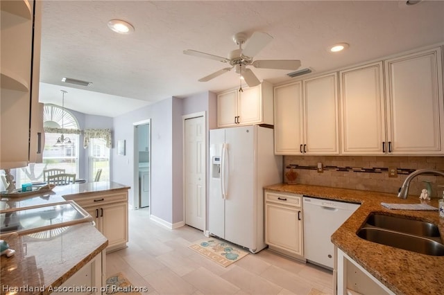 kitchen with stone counters, decorative backsplash, sink, and white appliances