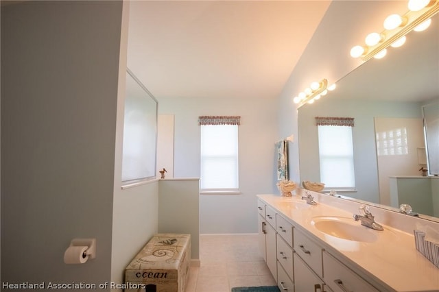 bathroom with tile patterned floors, vanity, and a wealth of natural light