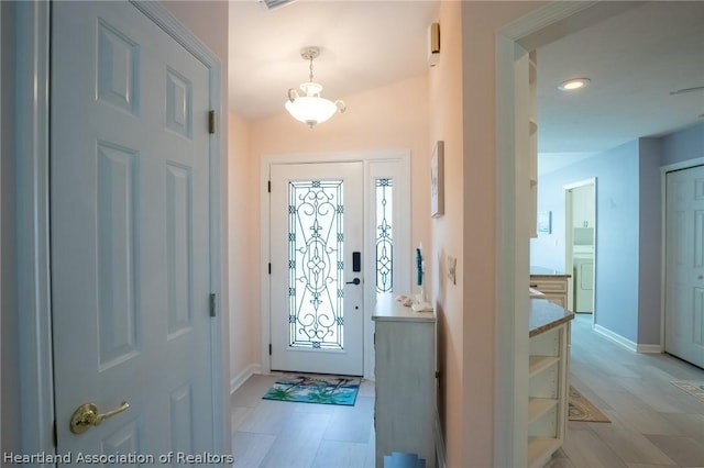 entryway featuring a chandelier and washer / clothes dryer