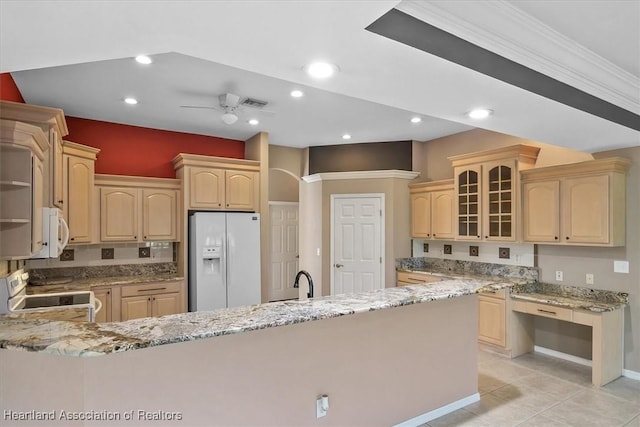 kitchen with light brown cabinetry, light stone counters, ornamental molding, white appliances, and ceiling fan