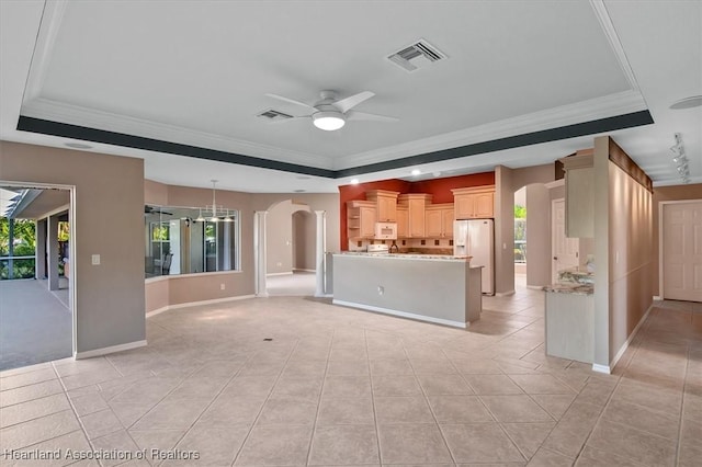 unfurnished living room with light tile patterned floors, a raised ceiling, ceiling fan, and ornamental molding