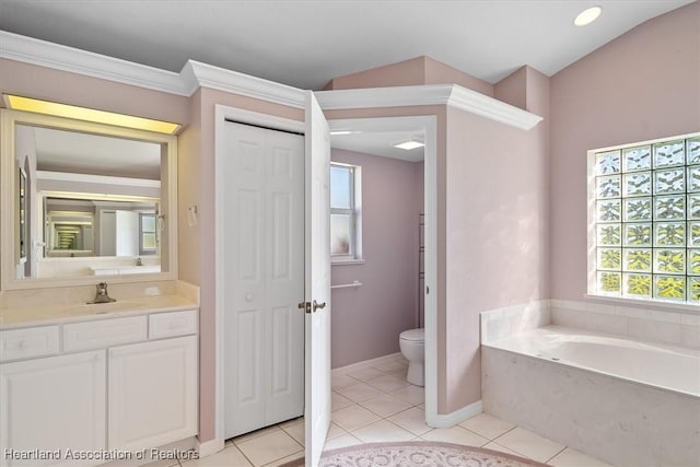 bathroom featuring tile patterned floors, a tub to relax in, vanity, and toilet