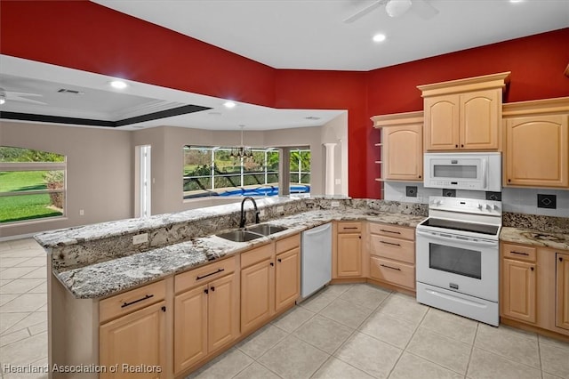 kitchen featuring light stone countertops, light brown cabinetry, white appliances, and sink