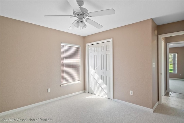 unfurnished bedroom with a closet, ceiling fan, and light colored carpet