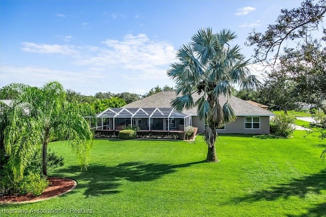 back of house with a lanai and a yard