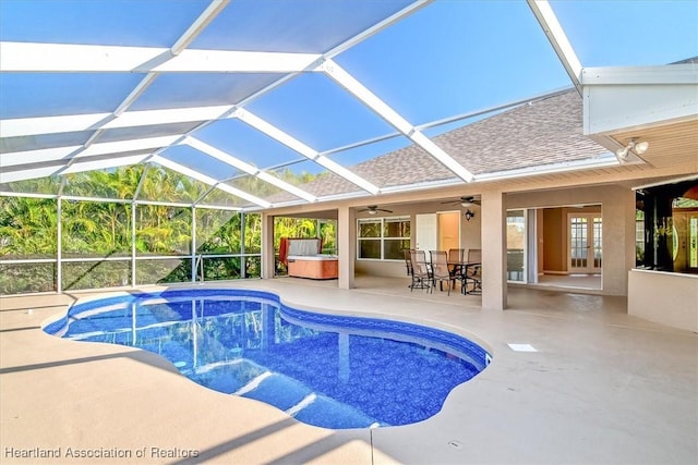 view of pool with glass enclosure, french doors, ceiling fan, a patio area, and a hot tub