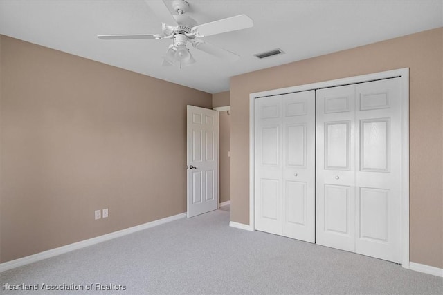 unfurnished bedroom featuring light colored carpet, a closet, and ceiling fan