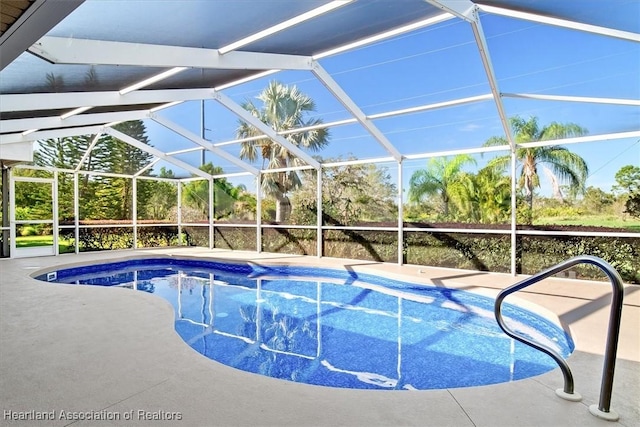 view of pool featuring glass enclosure and a patio area