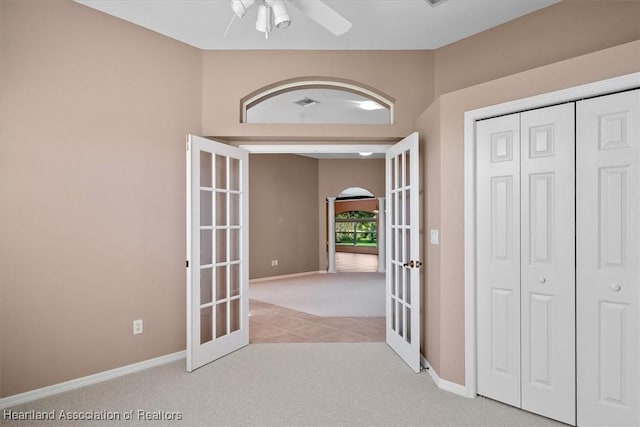 hall featuring light colored carpet and french doors