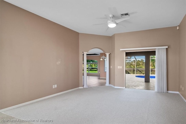 empty room with ornate columns, ceiling fan, and light carpet