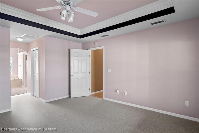 spare room with ceiling fan, a raised ceiling, and ornamental molding