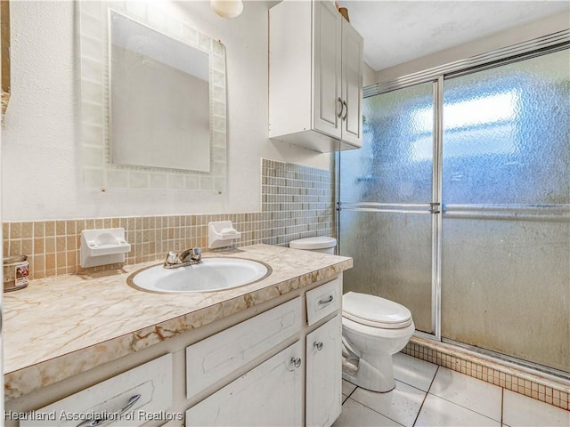 bathroom featuring a shower stall, vanity, toilet, and tile patterned floors