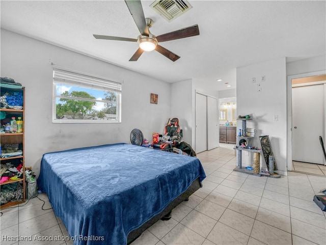 bedroom with visible vents, ceiling fan, ensuite bathroom, and light tile patterned floors