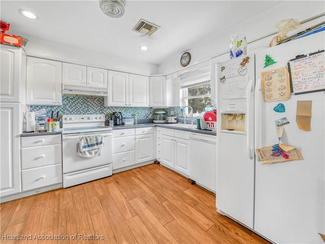 kitchen with visible vents, white cabinets, a sink, white appliances, and under cabinet range hood