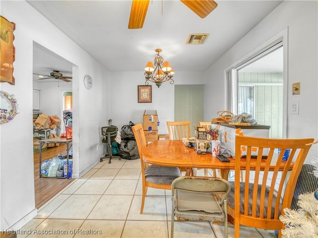 dining area with ceiling fan with notable chandelier, visible vents, and light tile patterned floors