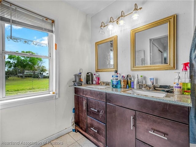 bathroom featuring double vanity, a sink, and tile patterned floors