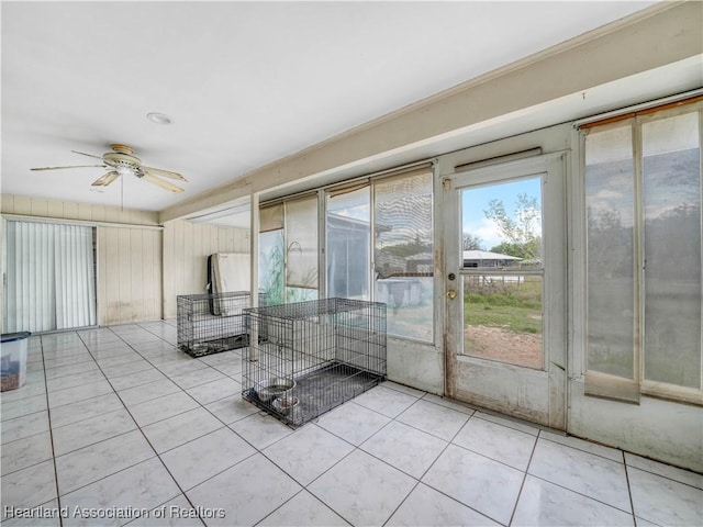 unfurnished sunroom featuring ceiling fan