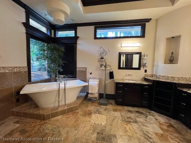 2230 Lake Ariana Blvd, Auburndale, FL 33823 - bathroom with vanity, a soaking tub, healthy amount of natural light, and tile walls