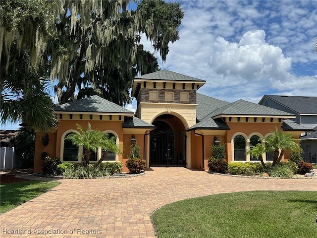 2230 Lake Ariana Blvd, Auburndale, FL 33823 - mediterranean / spanish home with stucco siding, stone siding, and decorative driveway