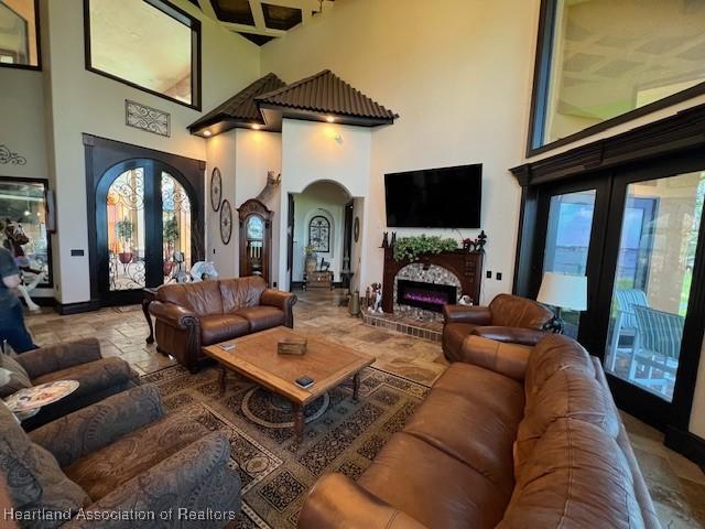 2230 Lake Ariana Blvd, Auburndale, FL 33823 - living room featuring arched walkways, french doors, a high ceiling, and plenty of natural light