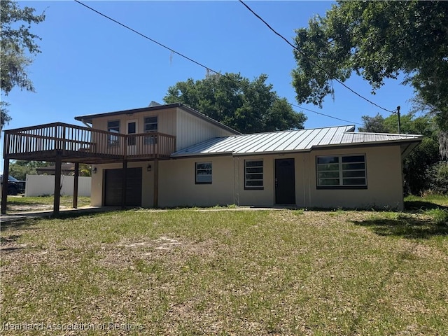 view of front of home with a garage, a front yard, metal roof, and a standing seam roof