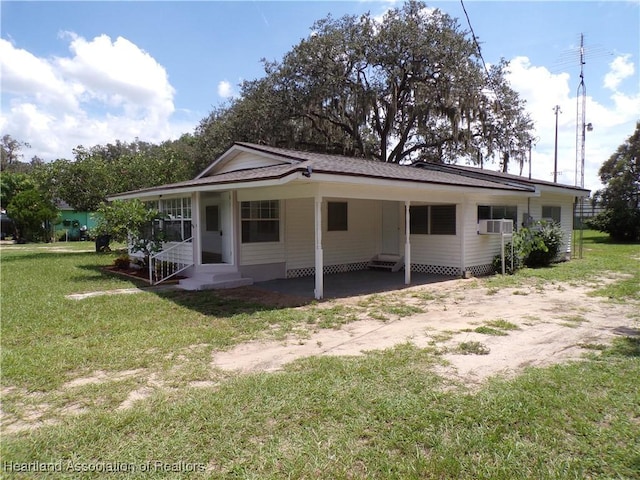 back of property with a lawn, cooling unit, and a carport