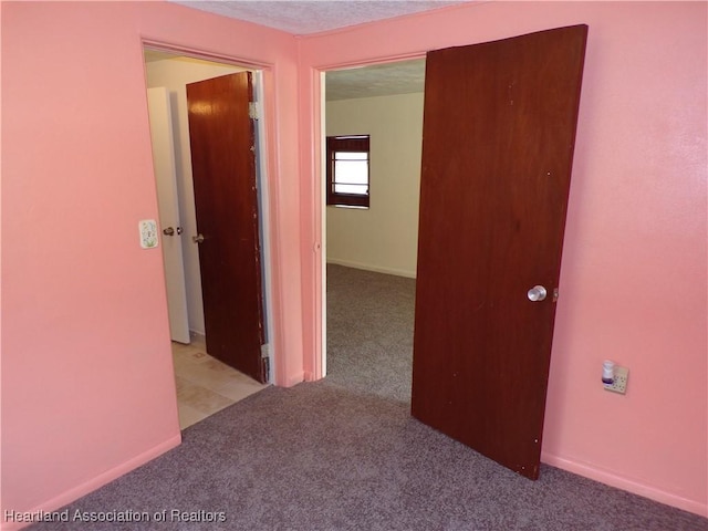 corridor featuring light colored carpet