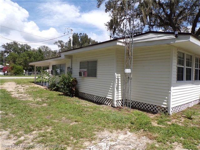 view of property exterior with a lawn and cooling unit