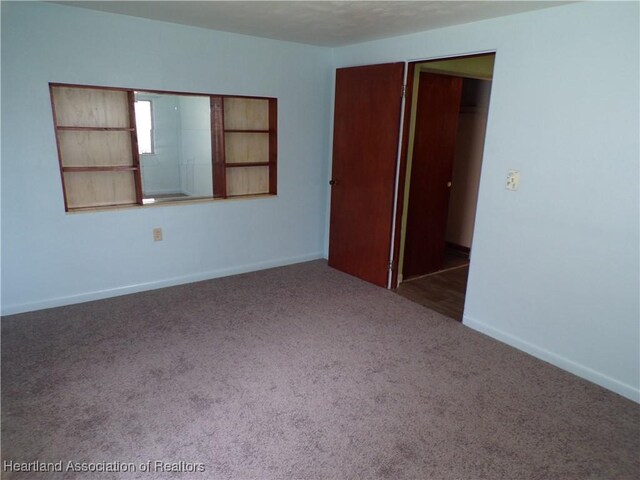 empty room featuring dark carpet