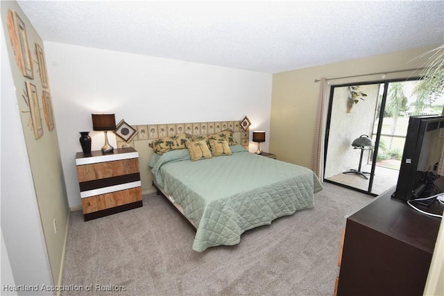 carpeted bedroom with a textured ceiling and access to outside