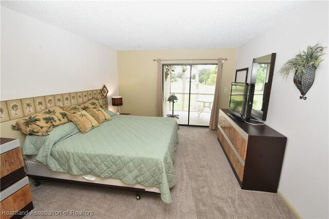 carpeted bedroom with a textured ceiling and access to outside