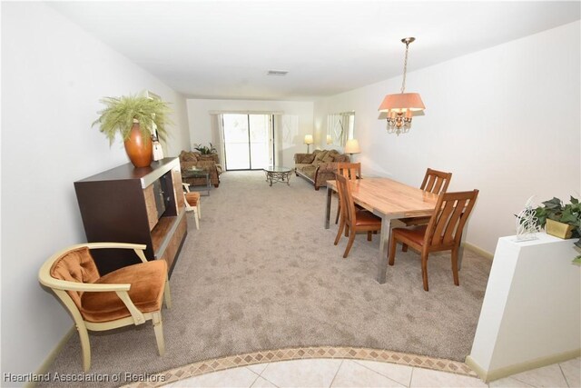 dining space featuring light carpet