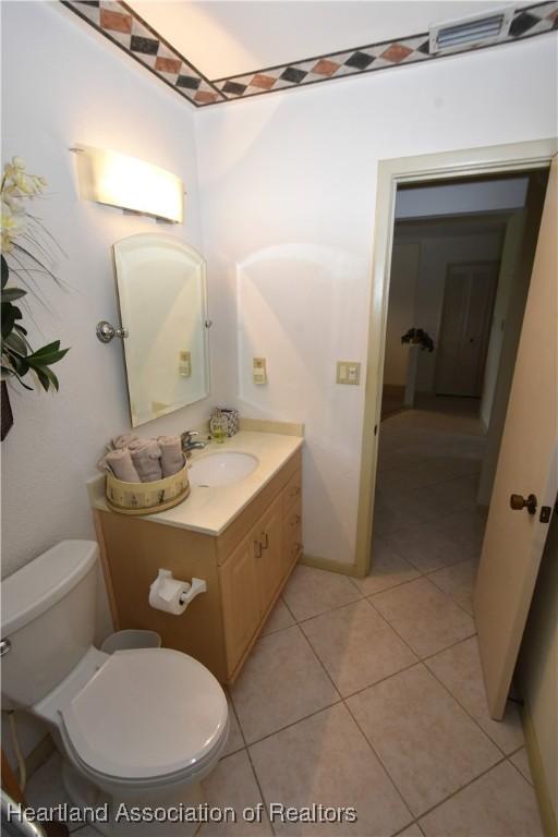 bathroom with tile patterned flooring, vanity, and toilet