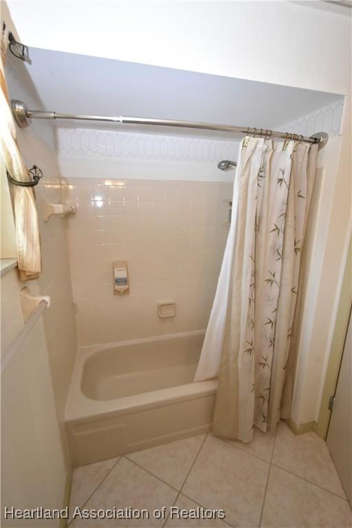 bathroom with tile patterned flooring and shower / bath combination with curtain