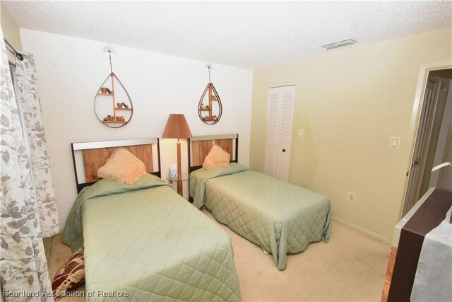 bedroom featuring carpet, a textured ceiling, and a closet