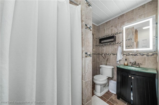 full bath with tile walls, tasteful backsplash, toilet, vanity, and tile patterned flooring