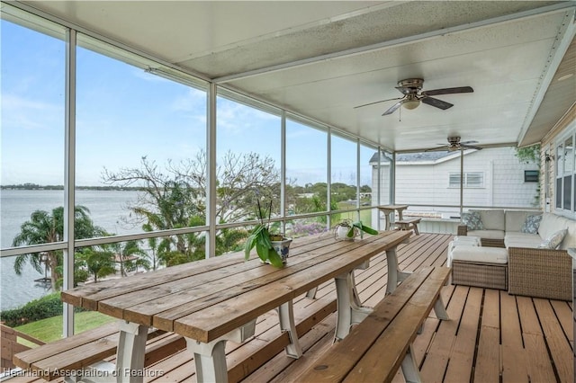 unfurnished sunroom with a water view and a ceiling fan